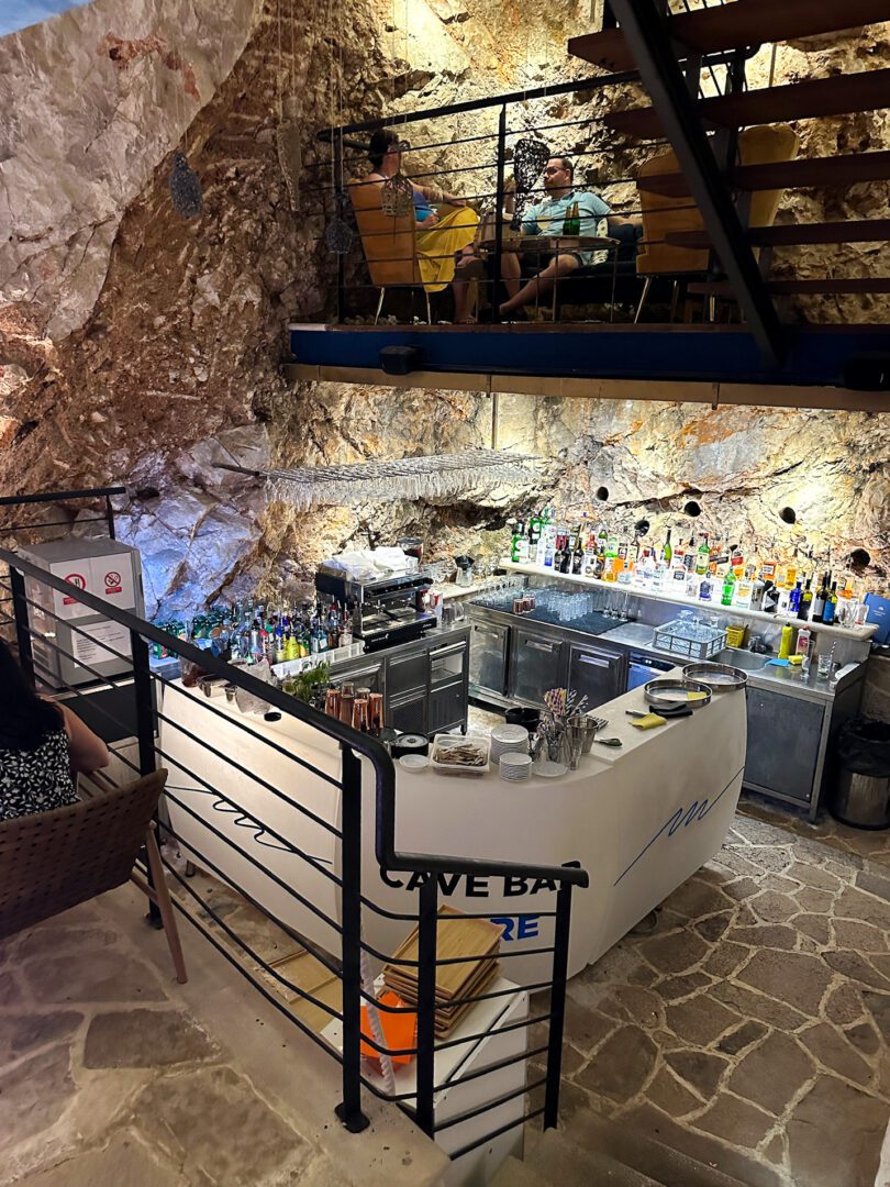 Underground setting of Cave Bar More in Dubrovnik, featuring a natural rock interior and stylish multi-level seating.