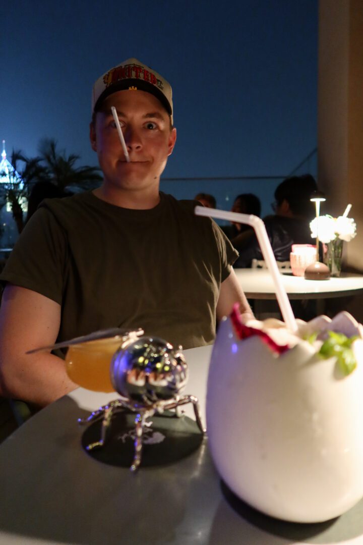 Playful cocktails served with flair at the Kimpton Maa-Lai rooftop bar in Bangkok, including one in a sculpted insect-shaped glass, set the tone for a fun night out.