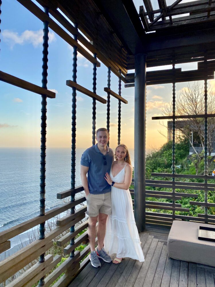 Couple posing at Alila Villas Uluwatu’s iconic sunset cabana, with ocean views and golden hour lighting creating a romantic Bali backdrop.