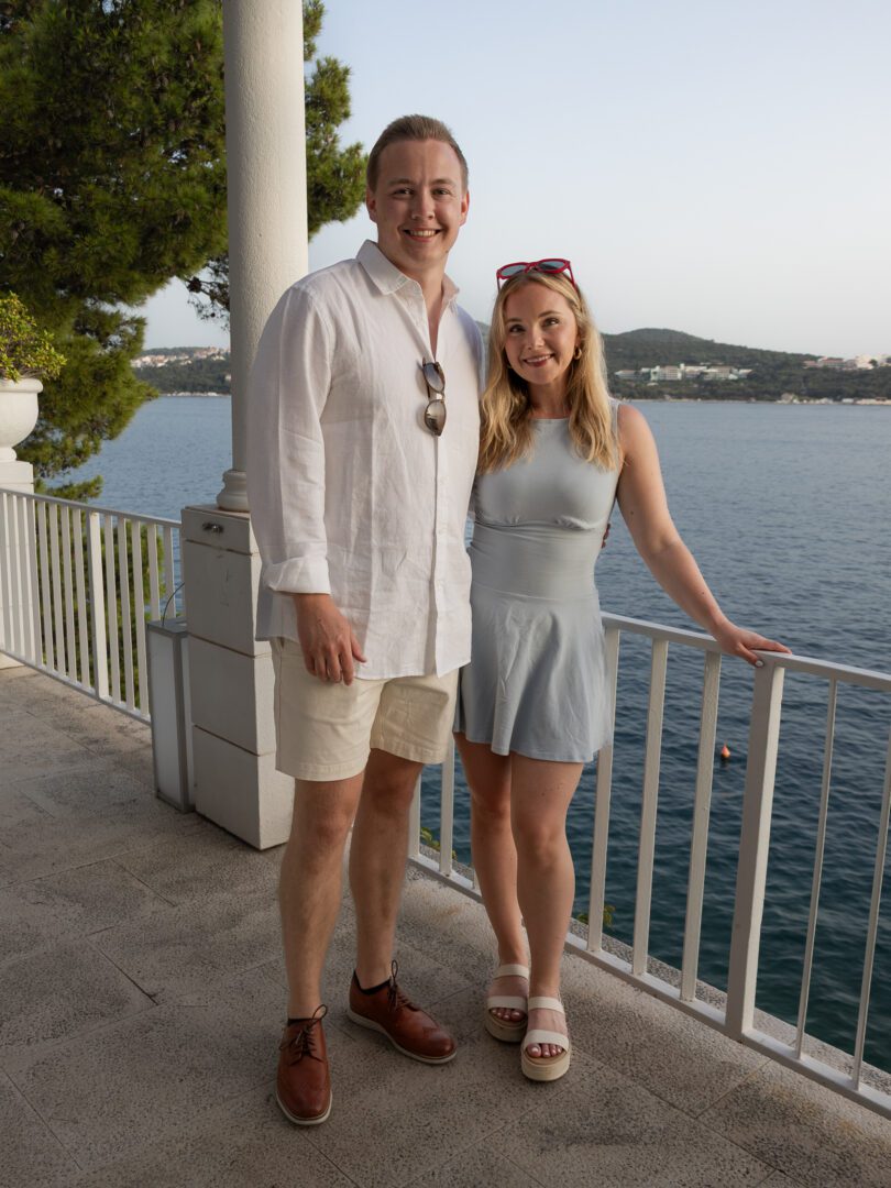 Couple standing on a seaside terrace with panoramic views of the Adriatic from a luxury villa near Dubrovnik.