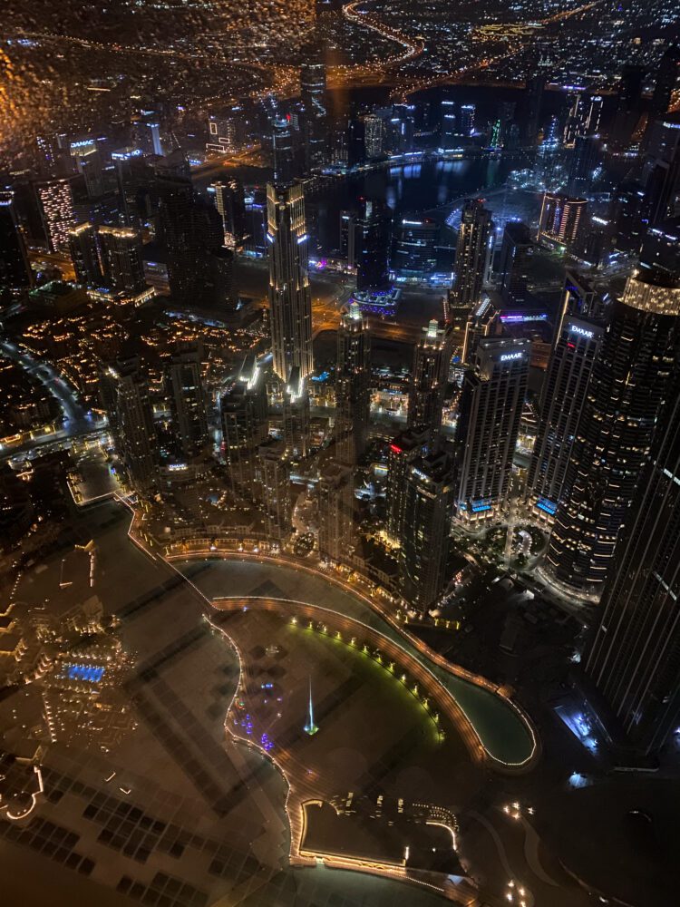 Aerial night view of Dubai’s glittering skyline and fountains, captured from the Atmosphere Lounge high in the Burj Khalifa.