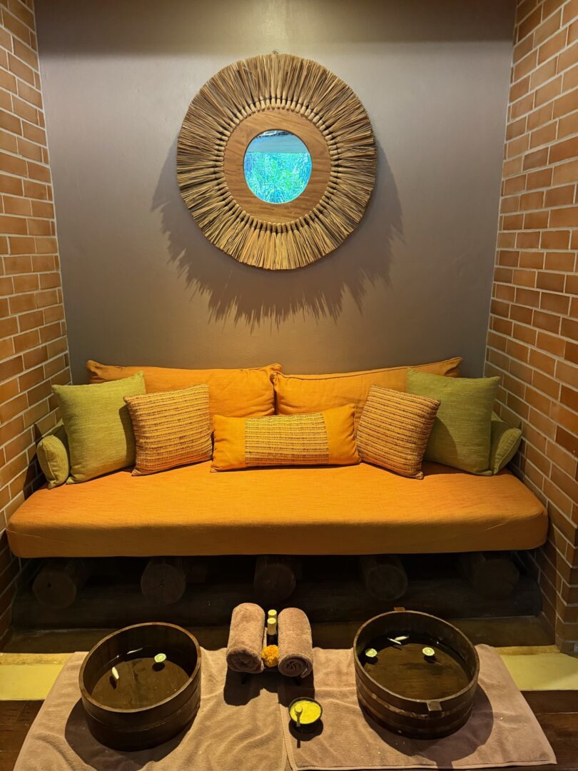 Cozy foot bath area at Rayavadee Spa featuring warm earth tones, plush cushions, and wooden soaking bowls infused with fresh citrus for a relaxing pre-treatment ritual.