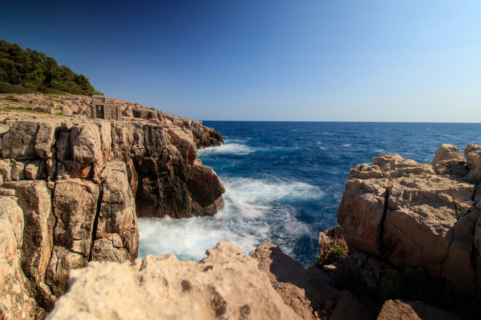 Rugged coastline and crashing waves on Lokrum Island, showcasing its wild natural beauty and dramatic cliffside terrain.
