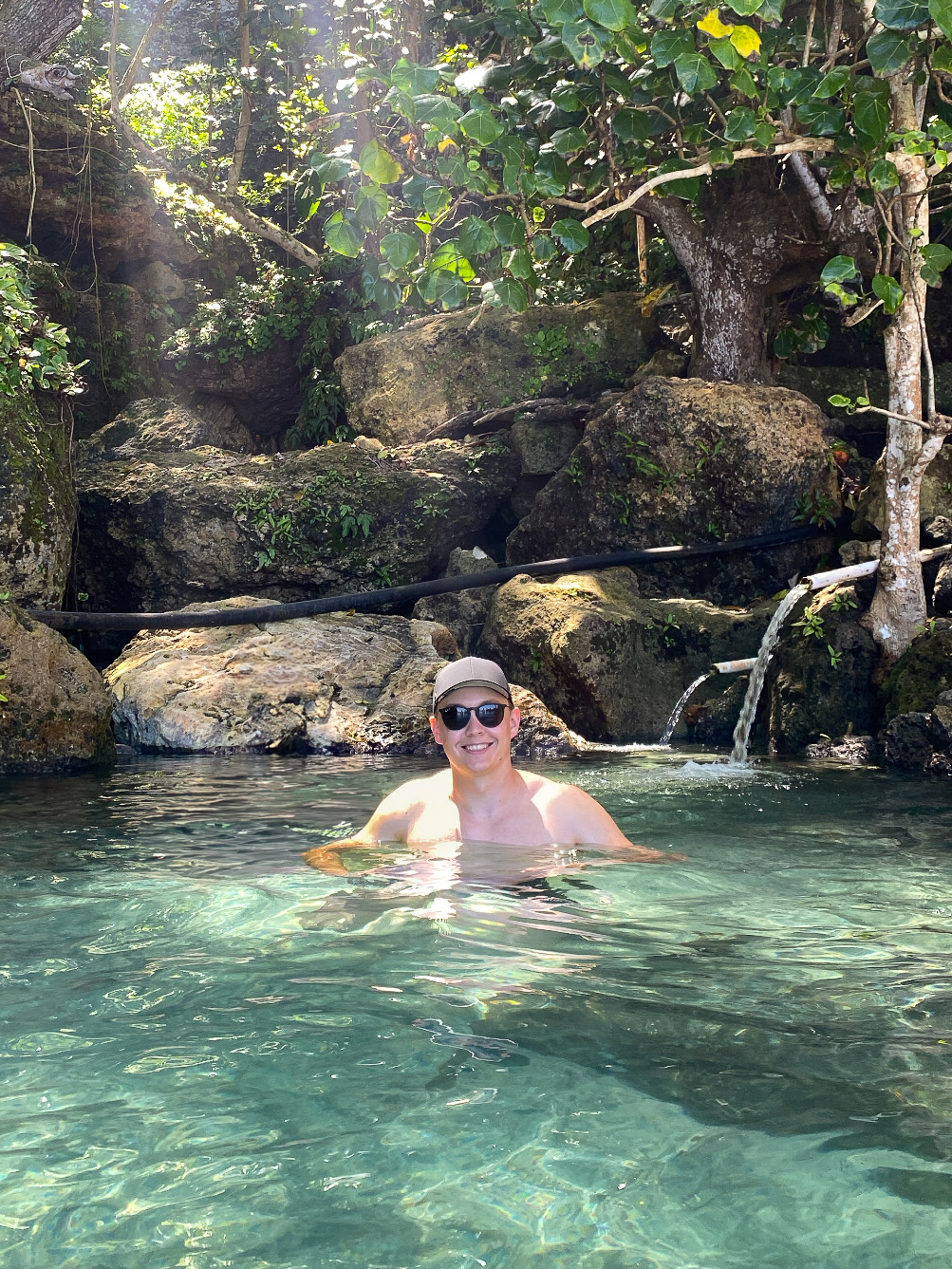 Crystal-clear water and lush jungle surroundings at the hidden natural pools of Tembeling Beach on Nusa Penida.