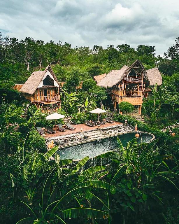 Scenic jungle resort in Nusa Penida with bamboo villas and a natural-style pool surrounded by banana trees.