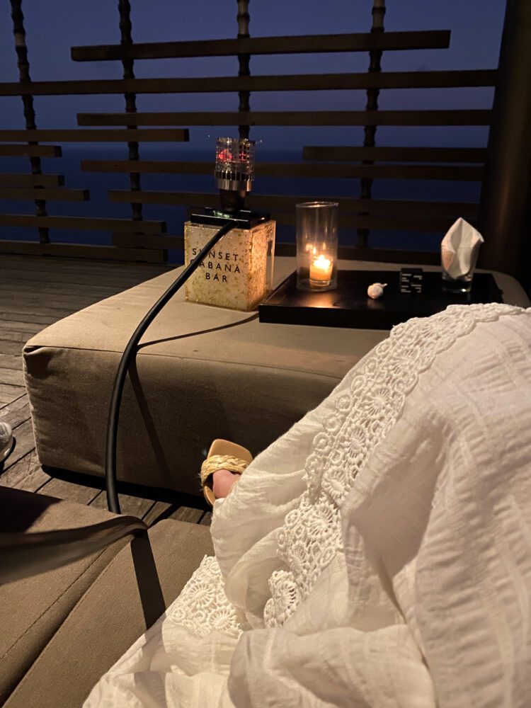 Evening ambiance at the Sunset Cabana Bar in Alila Villas Uluwatu, with candlelight and shisha overlooking the ocean horizon.