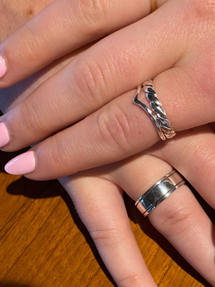 Close-up of handcrafted silver rings worn on a couple’s hands, made during a jewelry workshop in Sidemen, Bali.