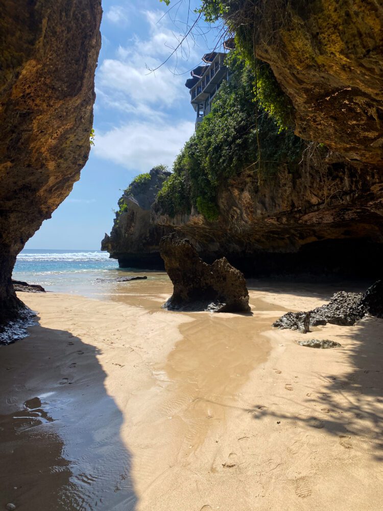 View of Suluban Beach framed by dramatic cliffs and rock formations near Uluwatu, Bali.