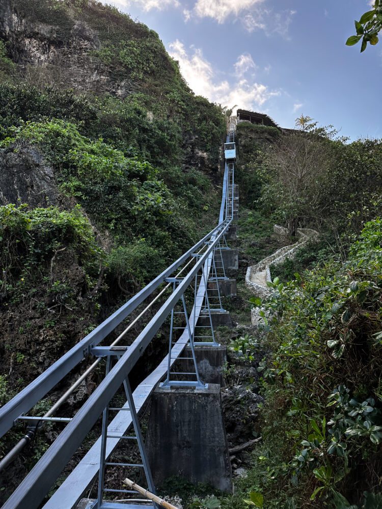 Steep cable car track leading down a lush cliffside at Sundays Beach Club in Uluwatu, Bali.