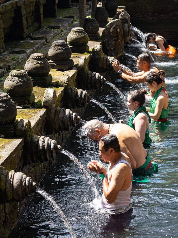 Visitors participating in a traditional purification ritual at Tirta Empul, a sacred Balinese water temple known for its holy spring.