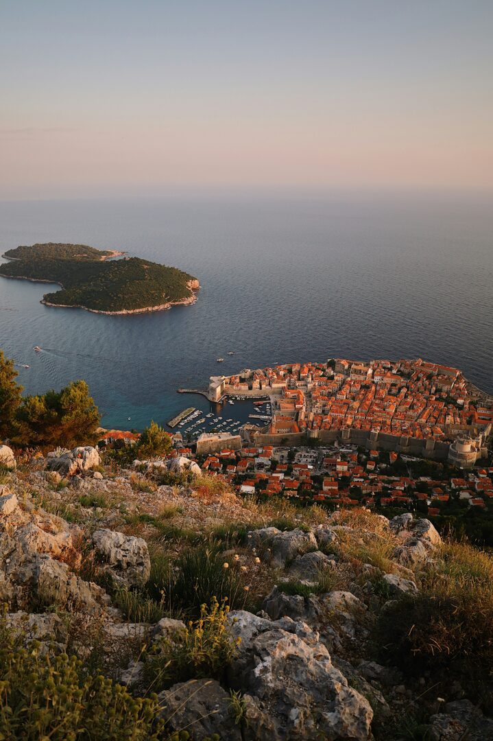 Elevated sunset view over Dubrovnik’s Old Town and harbor with Lokrum Island floating just offshore in the shimmering Adriatic.