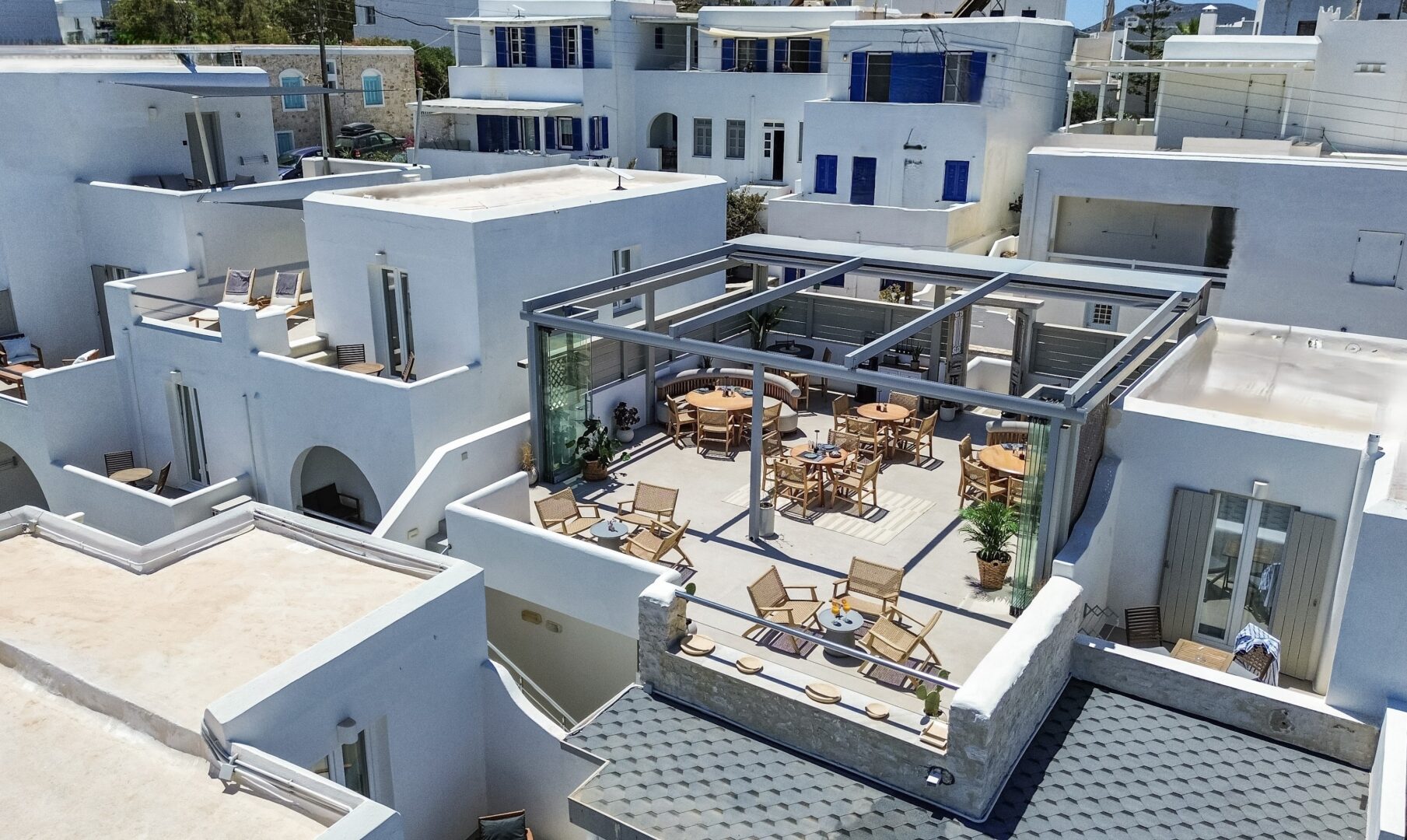 Rooftop terrace at Paliomylos Spa Hotel Paros with outdoor dining, Cycladic architecture, and views over Naoussa’s whitewashed town.