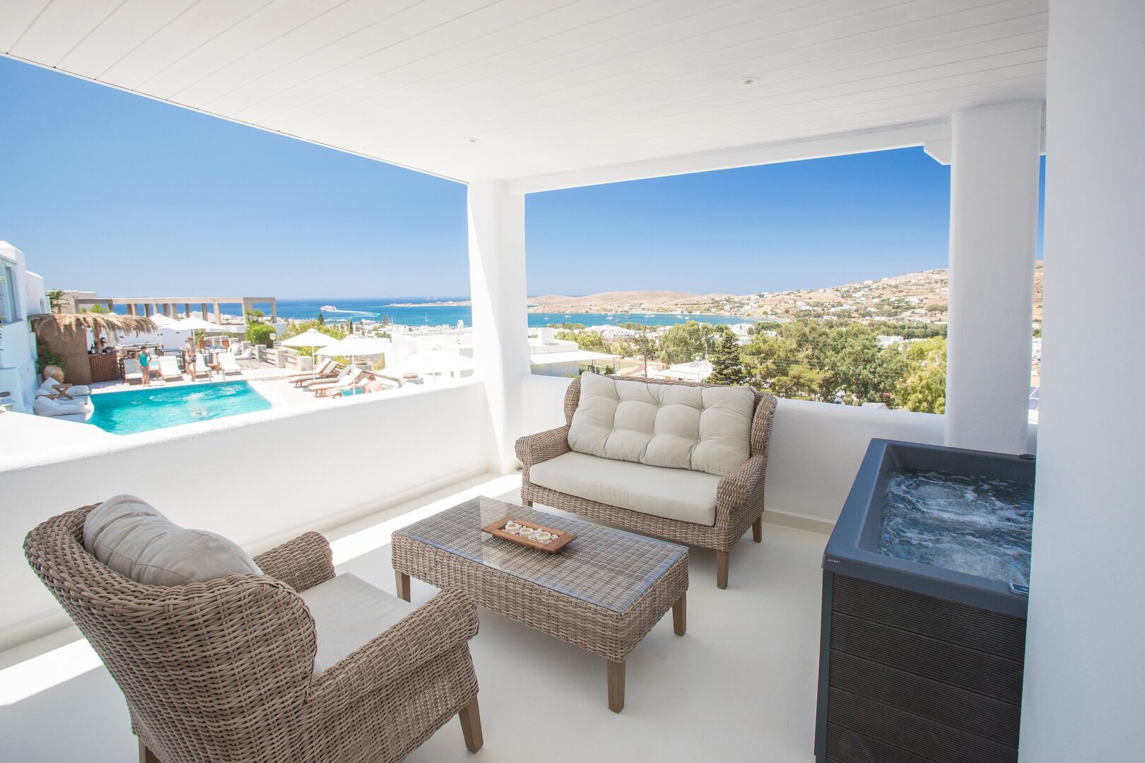 Comfort suite at Paros Palace Hotel with a private terrace, outdoor seating, hot tub, and panoramic sea views.