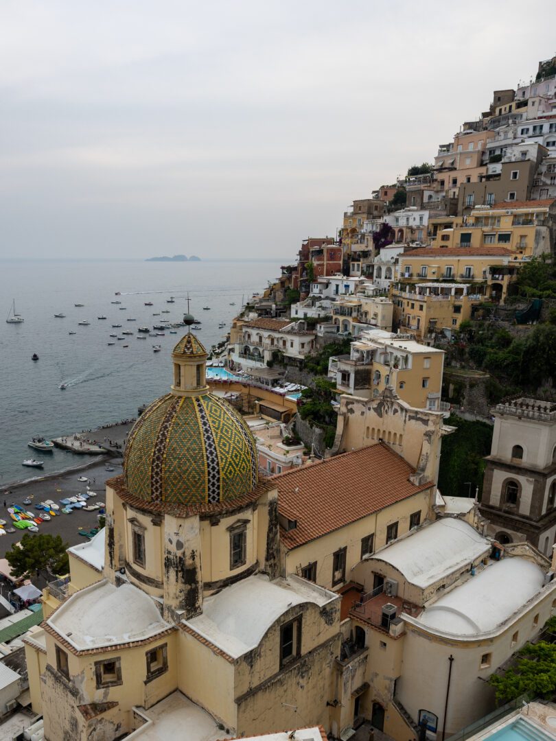 View of Positano’s iconic church dome and cascading cliffside homes from Aldo’s Cocktail Bar at Le Sirenuse Hotel.