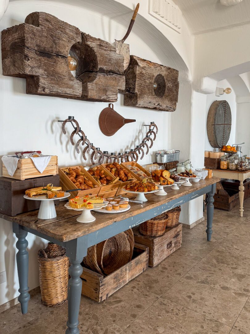 Rustic breakfast spread with pastries, cakes, and fruit at Masseria Borgo Ritella in Puglia, Italy.