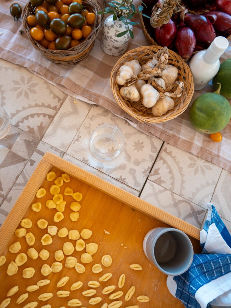 Fresh orecchiette pasta being made by hand during a traditional cooking class in Puglia, Italy.