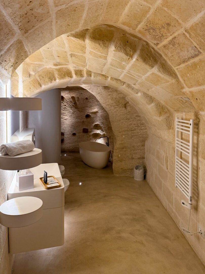 Modern cave-style bathroom with arched stone ceiling and freestanding tub at Aquatio Cave Luxury Hotel & Spa in Matera.