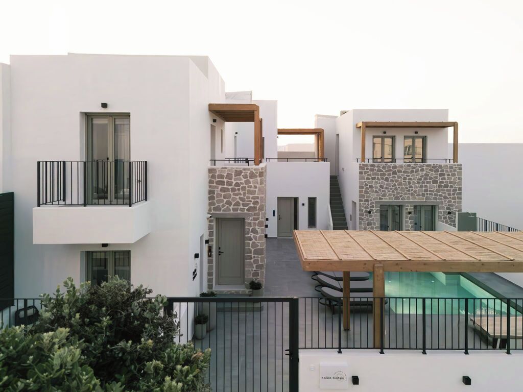 Modern Cycladic architecture at Kalea Suites Milos, featuring whitewashed buildings, stone accents, and a sleek pool area.