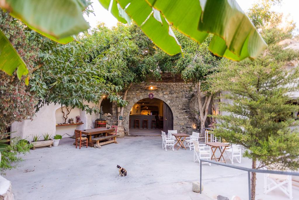 Charming courtyard at Kostantakis Winery & Residence with rustic stone architecture, shaded seating, and a tranquil vineyard ambiance in Pollonia.