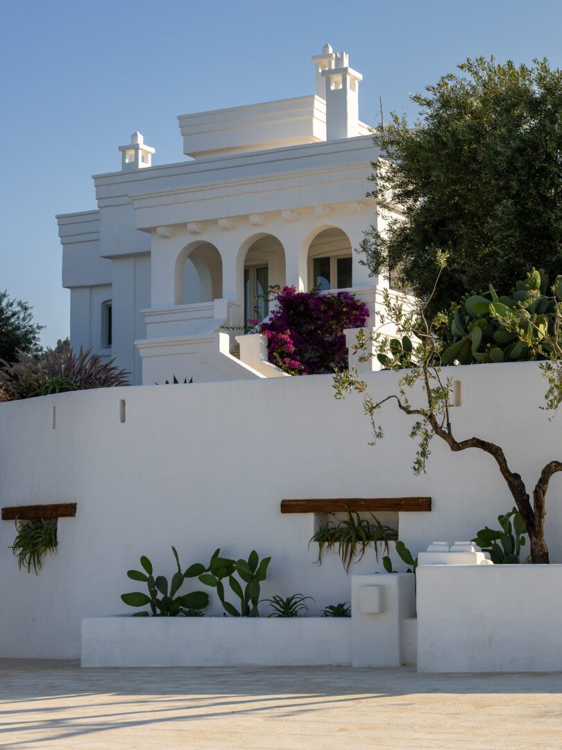 Elegant whitewashed facade of Masseria Borgo Ritella, a luxury hotel and wedding venue in Puglia, Italy.