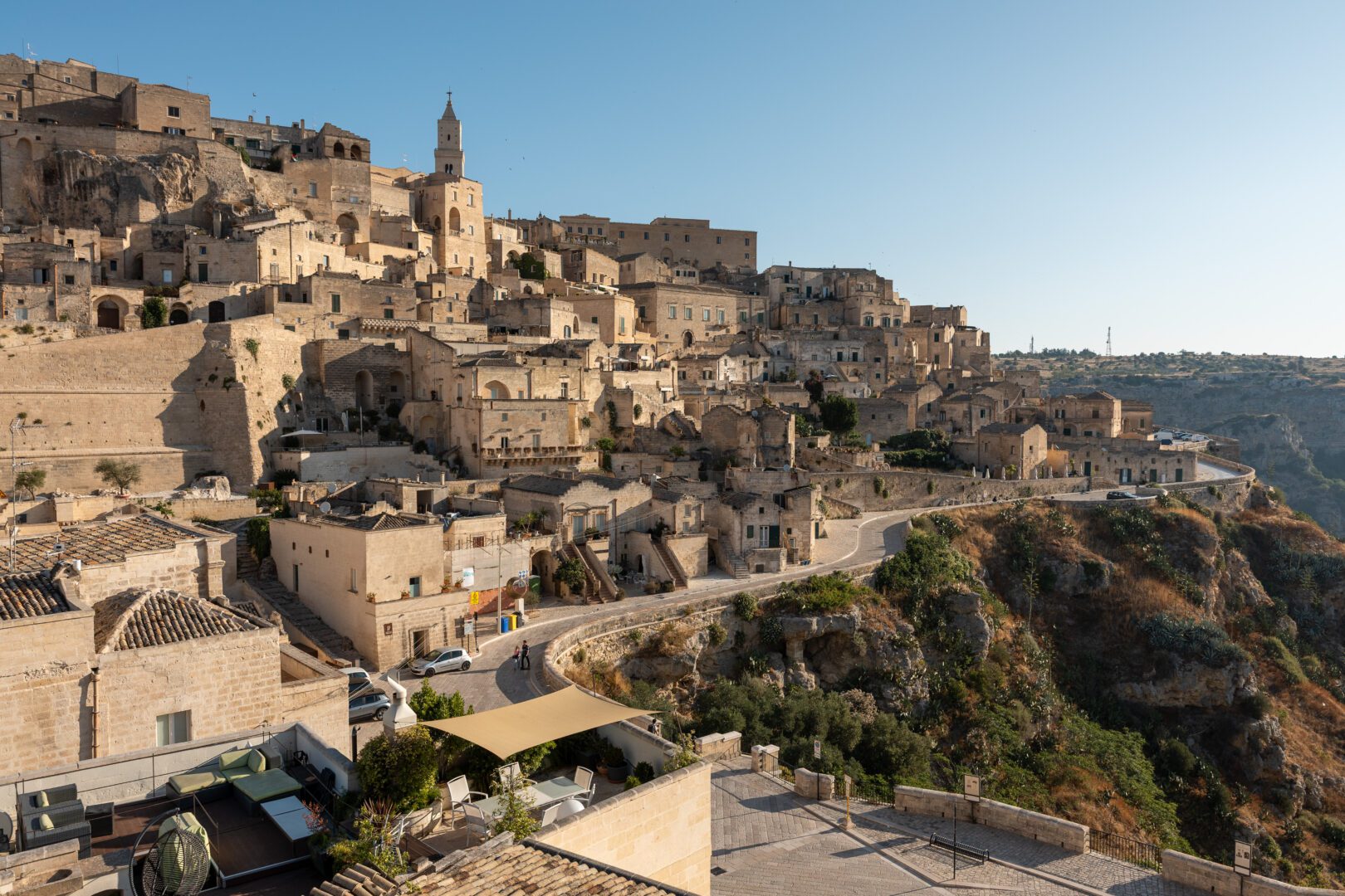 Scenic overlook of Matera’s hilltop cave dwellings and winding roads illuminated by crisp morning sunlight.