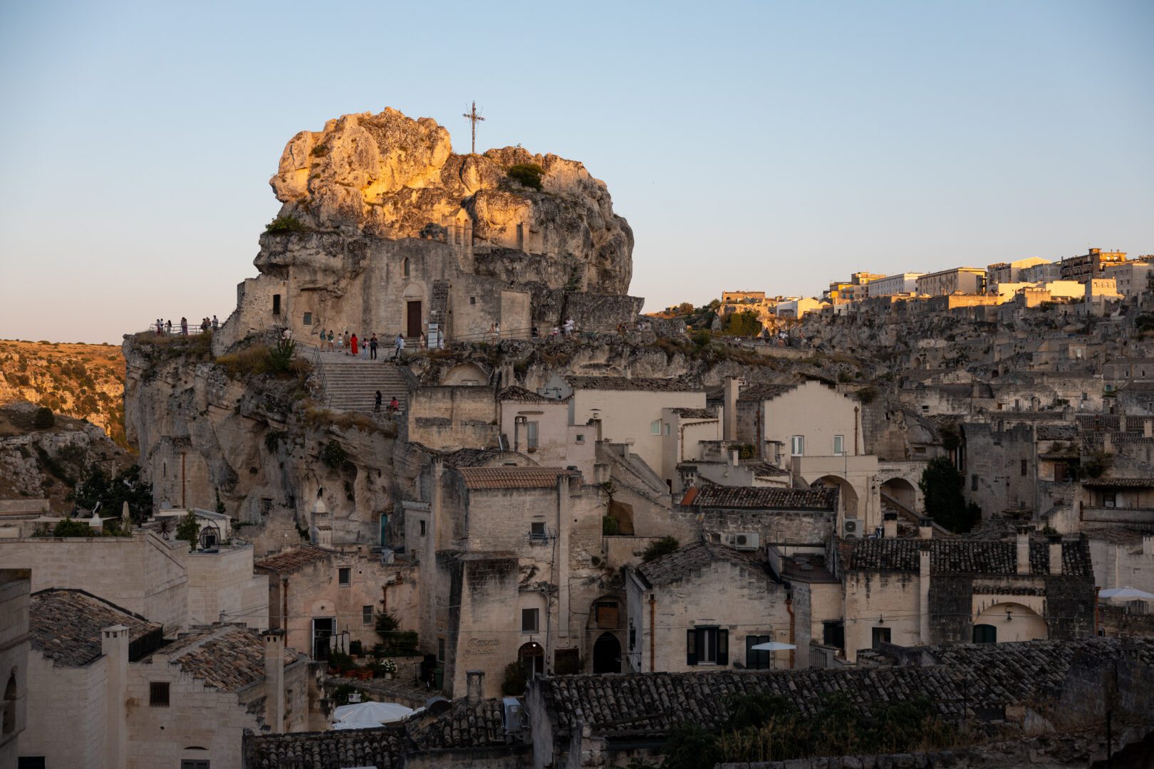 Golden light hitting the ancient stone church of Santa Maria de Idris perched atop the cave dwellings in Matera, Italy.