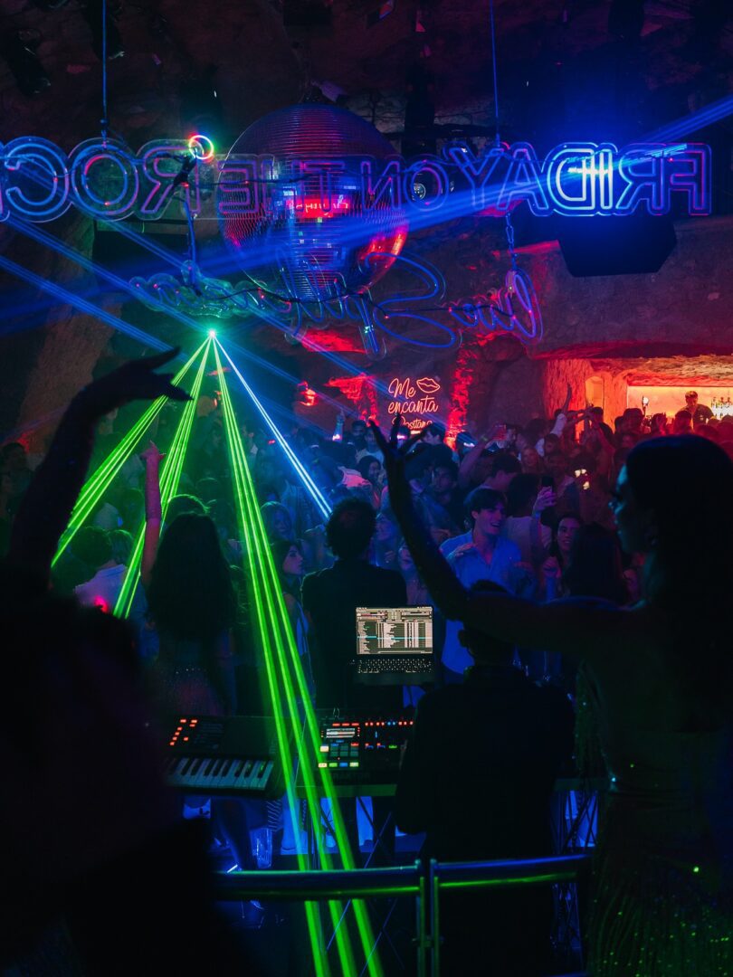 Laser lights fill the cave-like dance floor at Music on the Rocks, Positano’s iconic seaside nightclub, as a DJ performs for a lively, late-night crowd.