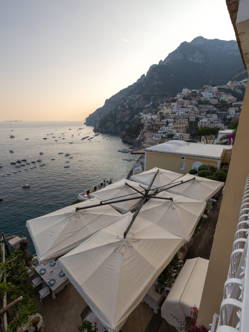 Golden hour view of Positano’s cliffside homes and the Tyrrhenian Sea from a balcony at Hotel Marincanto.