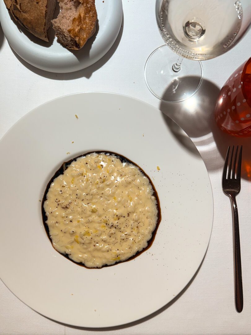 Creamy burrata risotto with lemon and licorice reduction at Michelin-starred Ristorante Vitantonio Lombardo in Matera.