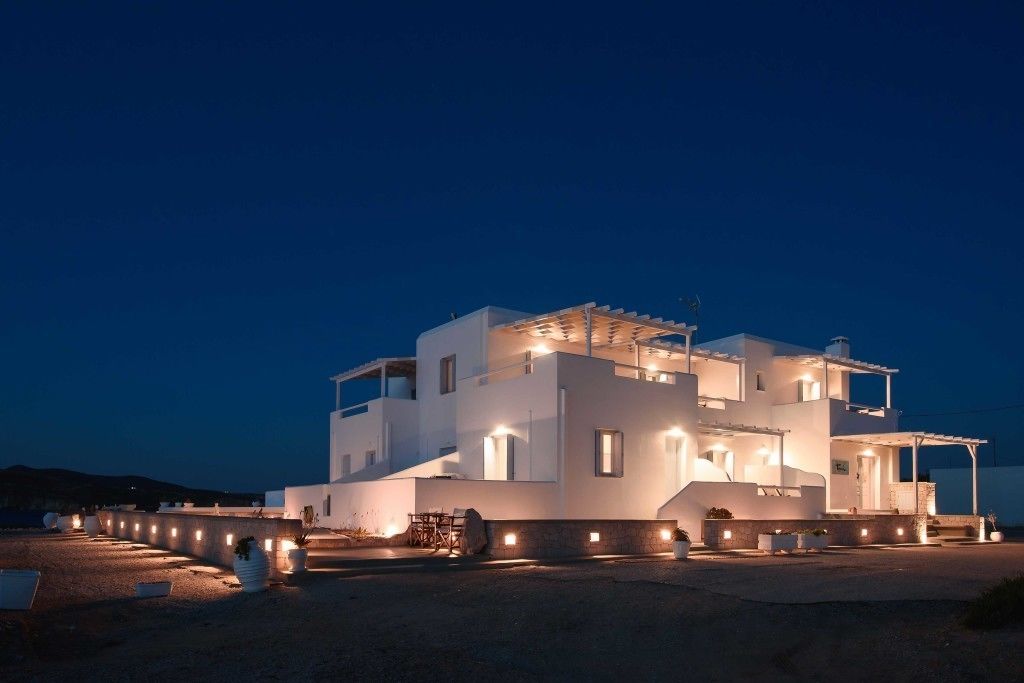 Tania Milos Hotel lit up beautifully at night with Cycladic architecture and a peaceful seafront setting in Pollonia.