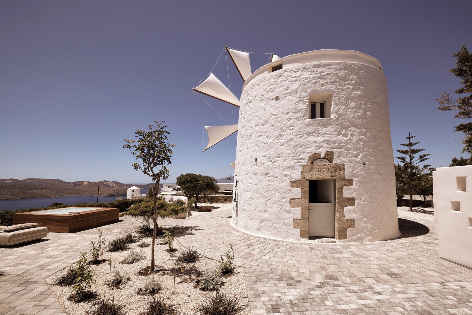 Restored traditional windmill at Windmill Karamitsos set above the sea with a private plunge pool and panoramic coastal views.