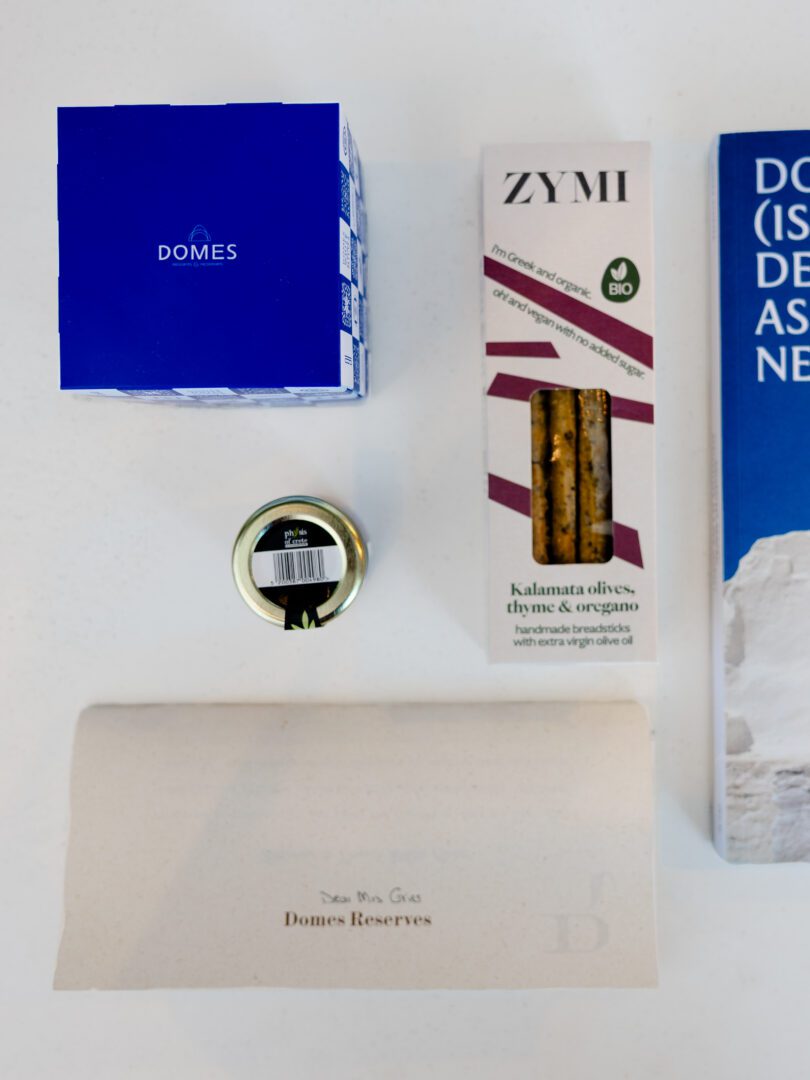 Complimentary welcome gift at Domes White Coast Milos including local breadsticks, olive products, and a personalized note.