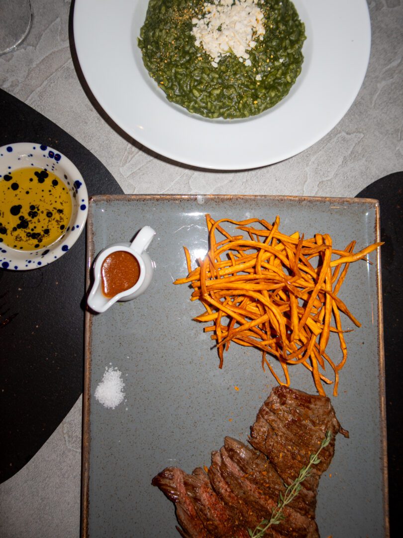 Grilled flap steak with sweet potato fries and spinach risotto at Oenosart Restaurant in Oia, Santorini.